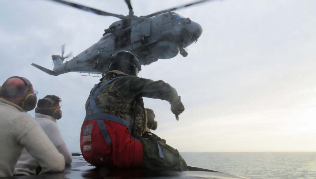 Looking up from a RN submarine at a Merlin Mk2 helicopter