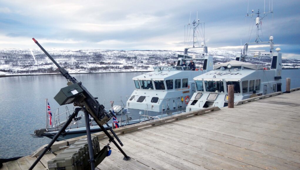 HMS Biter nearest the jetty and Blazer alongside in the Arctic and a machine gun (1)