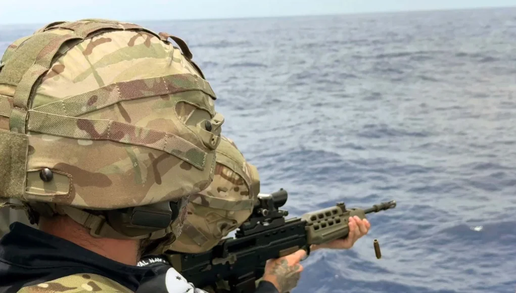 A cartridge is expelled as a gunner takes aim at a target
