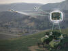 Military armored vehicle on a hillside with drones linked to a circuit board via glowing data lines.