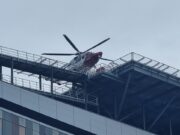Glasgow hospital helipad passes 3,000 landings since 2015 Emergency helicopter parked on a rooftop helipad above a modern glass office building