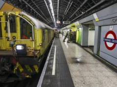 British Army runs NATO corps HQ in London Tube station Yellow maintenance locomotive on a London Underground platform at Charing Cross, with green wall tiles and passengers in the background.