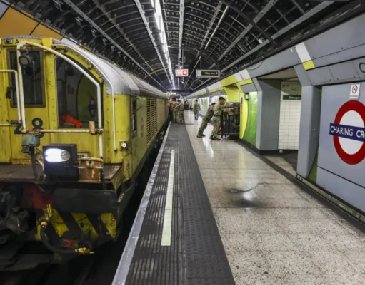 British Army runs NATO corps HQ in London Tube station Yellow maintenance locomotive on a London Underground platform at Charing Cross, with green wall tiles and passengers in the background.