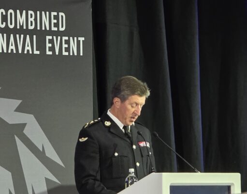 CNE 2026 a huge success as hybrid navy takes centre stage Military officer in dress uniform delivering a speech at a podium during a Combined Naval Event.