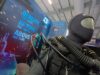 Life-size deep-sea diver suit with hoses on display at a trade show, blue signage reading 'Beneath the waves beyond the limits above all else' in the background.