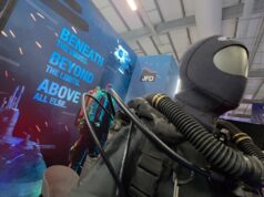 JFD talks military diving demands and new rebreather at CNE Life-size deep-sea diver suit with hoses on display at a trade show, blue signage reading 'Beneath the waves beyond the limits above all else' in the background.