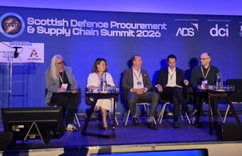 Primes say supply chain must change at DPRTE Scotland Five panelists seated on stage at the Scottish Defence Procurement & Supply Chain Summit 2026, with a blue-lit backdrop and sponsor logos.