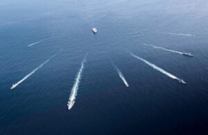 NATO hunts submarines in the Norwegian Sea Aerial view of several motorboats leaving white wake trails across deep blue ocean surface (six boats visible).