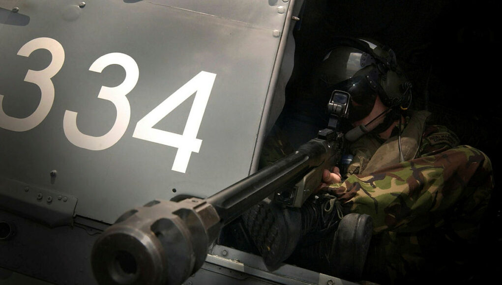 45145981.jpg.iCfQrrKBMsUzhedfYBMA.4oz3orQwzH Military helicopter side with large white '334' numbers and a crewman in camouflage sitting at a mounted gun in the open hatch, aiming outward.