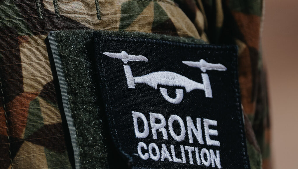 55296585553_c6d42966c4_k Close-up of a black Velcro patch with a white winged emblem on camouflage military uniform.