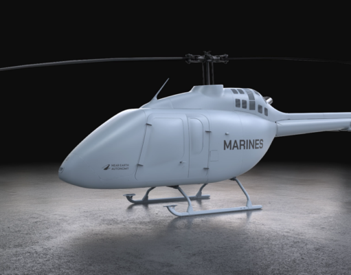 Light gray Marine helicopter with 'MARINES' on the side, parked on a concrete floor in a dark studio.