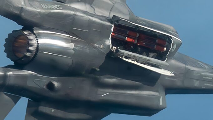 F-35B completes first flight with British SPEAR 3 missile Close-up of a damaged metallic sculpture resembling a fighter jet, with jagged edges and exposed orange interior components against a blue sky.