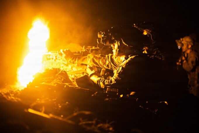US, Philippine armies open Salaknib 2026 exercise Soldier in night-vision gear firing a rifle beside a large orange flame at night
