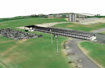 Royal Marines to power new rifle ranges with wind and solar 3D aerial view of a solar farm with rows of panels and a wind turbine beside a runway-like airstrip on green fields.