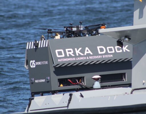 Orka Dock autonomous launch and recovery system on a gray watercraft, with drones on top and the text 'Orka Dock' visible on the side