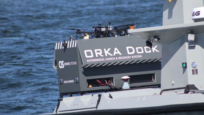 Orka Dock autonomous launch and recovery system on a gray watercraft, with drones on top and the text 'Orka Dock' visible on the side