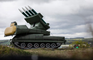 RAF using inflatable SAM sites for pilot training Large green mobile missile launcher with four missiles raised on a field under a cloudy sky.
