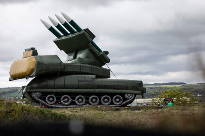 RAF using inflatable SAM sites for pilot training Large green mobile missile launcher with four missiles raised on a field under a cloudy sky.