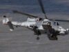 Britain’s Martlet missile reaches full capability on Wildcat Grey military helicopter in flight over water, with rockets mounted on its side and rotor blur indicating motion.