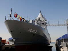 Leonardo signs huge naval combat systems deal for Kuwait Large gray naval vessel named P6202 docked at a pier, with signal flags along the bow and a gangway extending to shore.