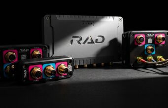 Black rugged avionics modules with gold round connectors and pink/blue label panels around a central RAD unit.