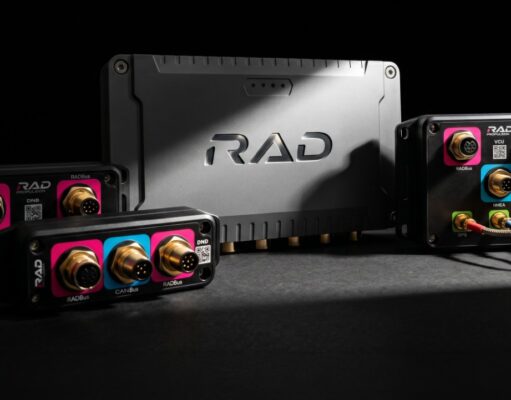 Black rugged avionics modules with gold round connectors and pink/blue label panels around a central RAD unit.