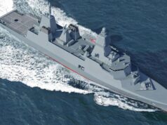 Modern gray destroyer cruising through open sea, bow to the right, leaving a frothy wake behind.