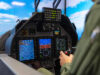 How simulation is speeding up the RAF pilot pipeline Pilot in a cockpit operating flight controls with touchscreen displays and avionics visible ahead of him to the blue sky outside the canopy.