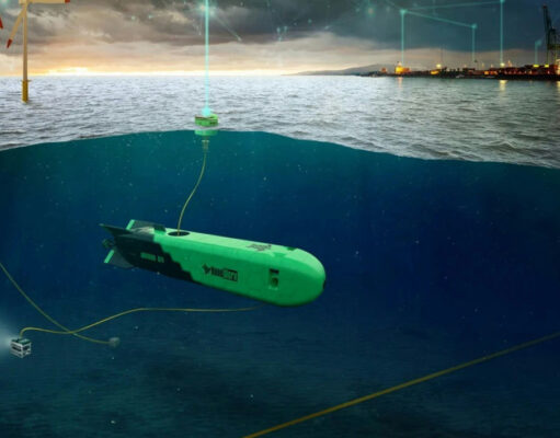 Green autonomous underwater vehicles tethered by cables on a seabed near an offshore wind farm and port at dusk, with the surface showing wind turbines and lights.