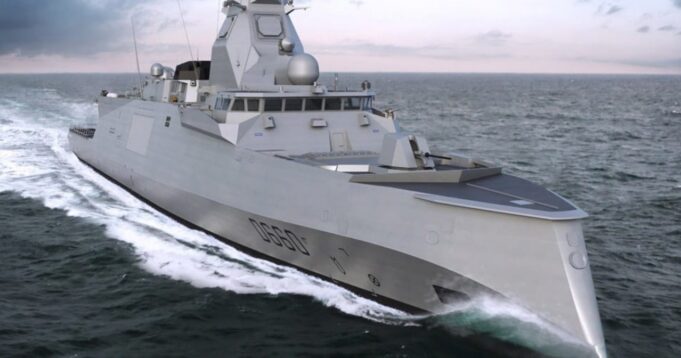 Gray stealth destroyer sailing at sea, angular superstructure cutting through white water.