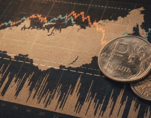 Western sanctions credibility damaged, expert warns Russian ruble coins placed on a stock market chart showing fluctuating lines and data.