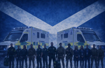 Scottish Ambulance Service backs reservists Emergency responders in uniform stand in front of two NHS emergency ambulances with a Scottish flag backdrop behind them.