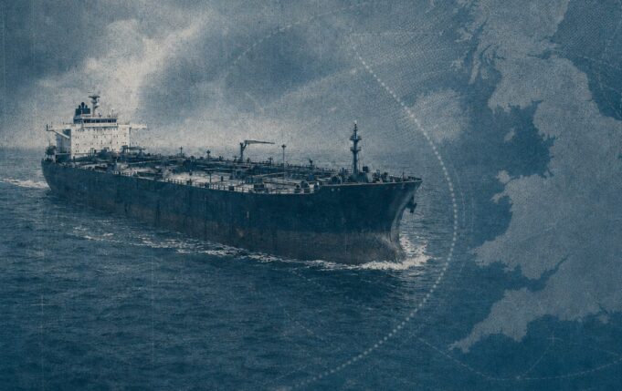 UK shadow fleet boardings: pledge made, no action taken Large oil tanker sailing on choppy blue ocean with a map-like blue overlay in the background, conveying global shipping routes
