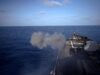 American destroyer opens fire in the Mediterranean Military ship’s flight/deck at sea with a smoke plume near the bow and open ocean ahead.