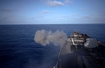 American destroyer opens fire in the Mediterranean Military ship’s flight/deck at sea with a smoke plume near the bow and open ocean ahead.