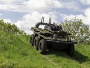 Leonardo deal lets IDV build the Viking UGV at scale Eight-wheeled armored military vehicle on a grassy slope under a cloudy sky, with equipment racks and antennas mounted on top.