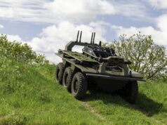 Leonardo deal lets IDV build the Viking UGV at scale Eight-wheeled armored military vehicle on a grassy slope under a cloudy sky, with equipment racks and antennas mounted on top.