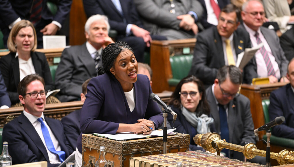 54427984364_6e364ddeb4_k Politician in a purple blazer speaks into a microphone at a ceremonial desk in a parliamentary chamber, with lawmakers watching.