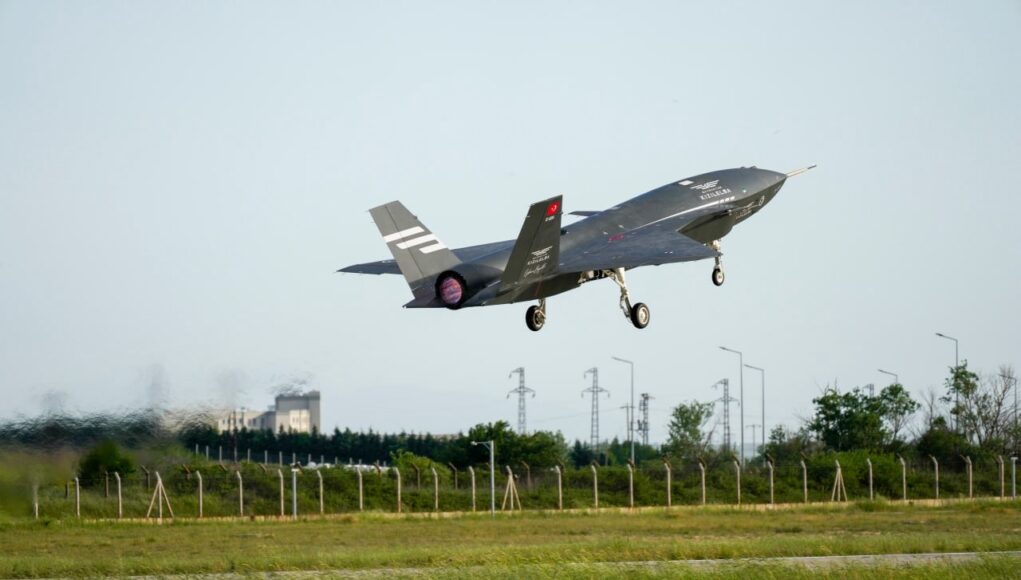 6 (1) Stealth fighter jet lifting off from a runway, low above a grassy field with a fence in the foreground.