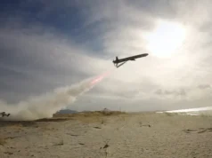 British long range deep-strike weapon passes key trial Air tanker plane releasing red retardant over a sandy beach as smoke rises from a ground fire nearby