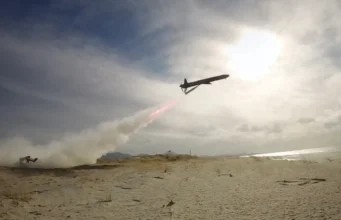 British long range deep-strike weapon passes key trial Air tanker plane releasing red retardant over a sandy beach as smoke rises from a ground fire nearby
