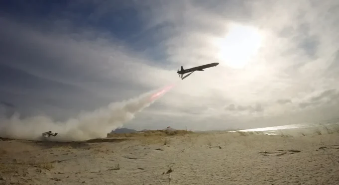 British long range deep-strike weapon passes key trial Air tanker plane releasing red retardant over a sandy beach as smoke rises from a ground fire nearby