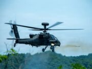 American Apaches fire rockets near the Korean DMZ Military attack helicopter in mid-flight firing a missile over a forested area