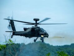 American Apaches fire rockets near the Korean DMZ Military attack helicopter in mid-flight firing a missile over a forested area