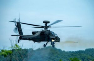 American Apaches fire rockets near the Korean DMZ Military attack helicopter in mid-flight firing a missile over a forested area