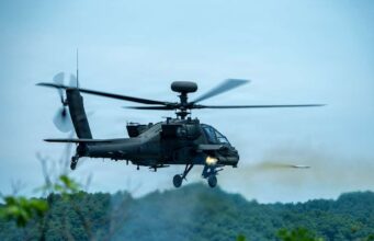 American Apaches fire rockets near the Korean DMZ Military attack helicopter in mid-flight firing a missile over a forested area