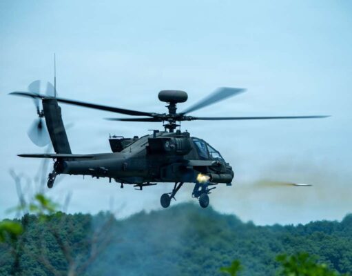 American Apaches fire rockets near the Korean DMZ Military attack helicopter in mid-flight firing a missile over a forested area