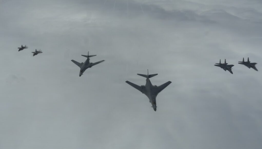 Astral Knight 26: F-15E F-35A B-1B Operations Six military aircraft flying in a loose formation across a cloudy sky.