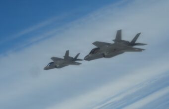 NATO issues first nuclear statement in message to Moscow Two gray fighter jets flying in formation across a blue sky.