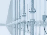 Australia exports over-the-horizon radar to Canada Row of snow-dusted streetlight posts along a railing in a snowy landscape, receding into the distance.